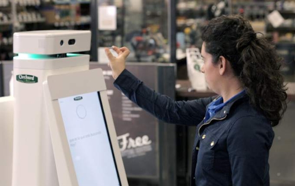 Woman interacting with OSHbot, Lowe's robot
