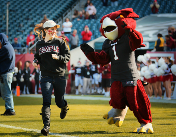 Kelly Dougherty, the winner of TUTV's Most Spirited Contest is shown running on to the football field with Hooter the Owl