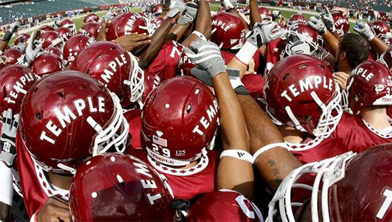Temple Football players in a huddle